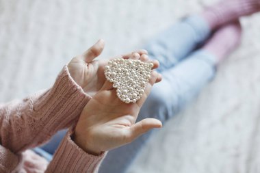 Erkek küçük inci kalp tutan eller