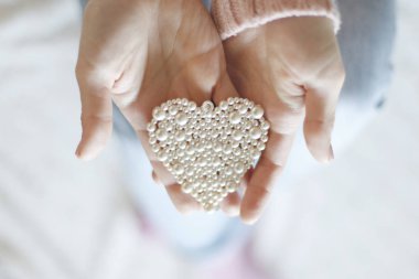 Erkek küçük inci kalp tutan eller