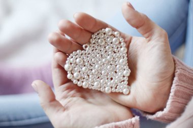 Erkek küçük inci kalp tutan eller