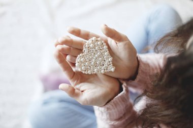 Erkek küçük inci kalp tutan eller