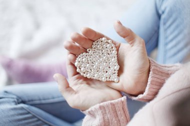 Erkek küçük inci kalp tutan eller