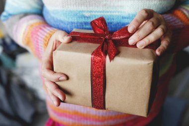 Kış giysileri hediye kutusu Noel zamanı önce tutan genç kadında doz kırpılmış