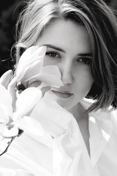 Jovem bela mulher modelo posando no jardim de magnolias florescendo . — Fotografia de Stock