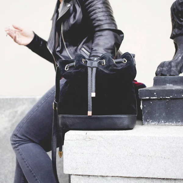 stylish girl with leather bag and black jacket at the street