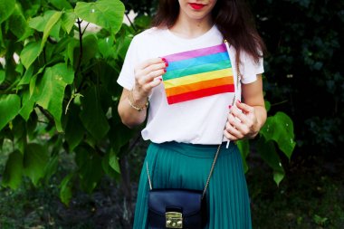 Lgbt hakları kavramı, el, doğanın zemininde, Lgbt bayrağı tutar. Doğada Lgbt bayrağı olan genç bir kız. 
