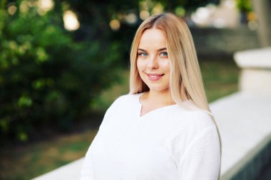 Sonbaharda şehir sokakta beyaz bluz giyen genç şık kadın. Rahat moda, zarif bir görünüm. Artı boyutu modeli. Sonbahar moda