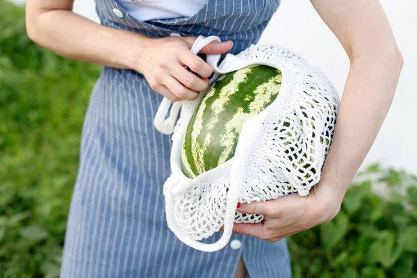 Summer lifestyle image. Watermelon, in cotton shopping bag, hipster girl