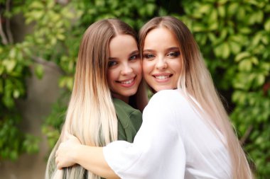 Parkta poz veren iki sarışın kız kardeş