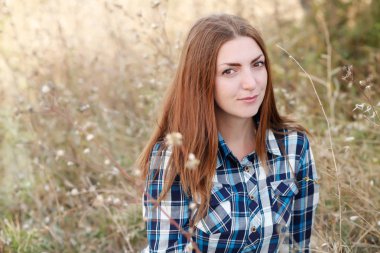 Ekose gömlekli genç kadın tarlada poz