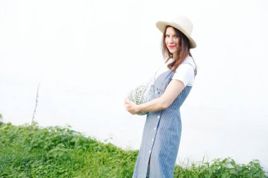 Bahçede örme çanta içinde karpuz taşıyan güzel kadın