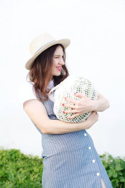 Örme çantada karpuz taşıyan genç kadın