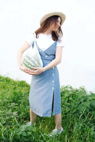 Bahçede örme çanta içinde karpuz taşıyan güzel kadın