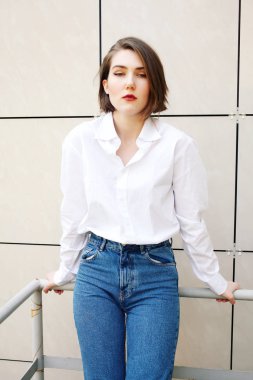 binanın yakınındaki korkulukta poz veren çekici kadın