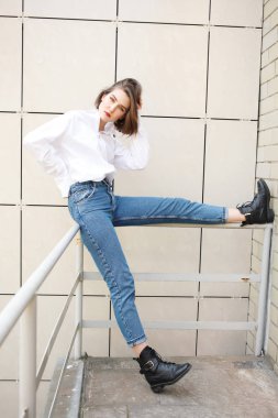 binanın yakınındaki korkulukta poz veren çekici kadın