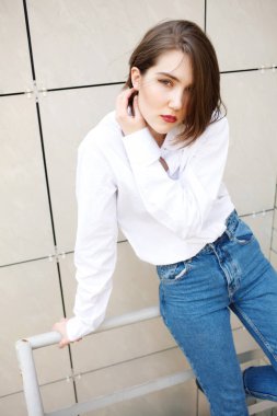 binanın yakınındaki korkulukta poz veren çekici kadın