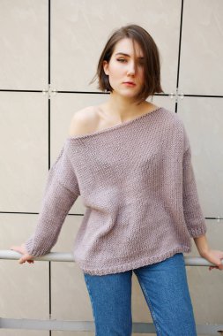 binanın yakınındaki korkulukta poz veren çekici kadın