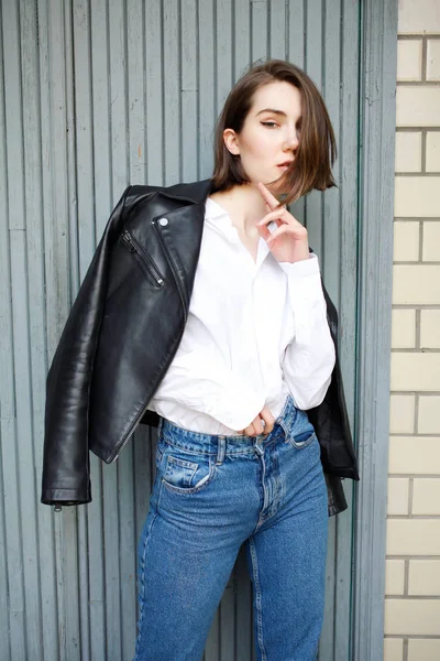 binanın yakınında poz veren ve kameraya bakan çekici kadın