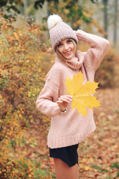 Młoda Kobieta Pozowanie Jesiennym Parku Trzymając Liść — Zdjęcie stockowe