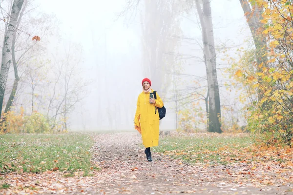 Sonbahar Parkında Poz Veren Sarı Yağmurluklu Genç Bir Kadın — Stok fotoğraf