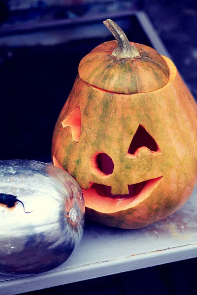 Halloween carved pumpkin and silver pumpkin