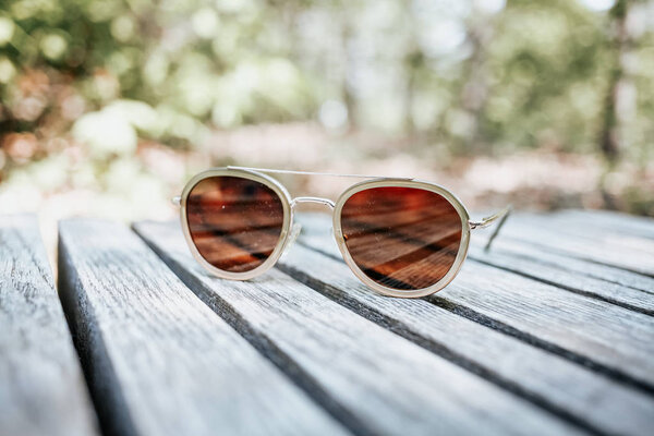 стильные женские солнечные очки на деревянной поверхности
