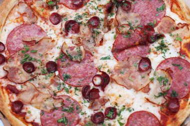 Domates soslu, peynirli, pastırmalı, sosisli ve baharatlı taze pizza. Temiz hava, piknik, tatil köyünde yemek..