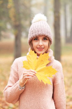Güz parkında güzel genç bir kadın.