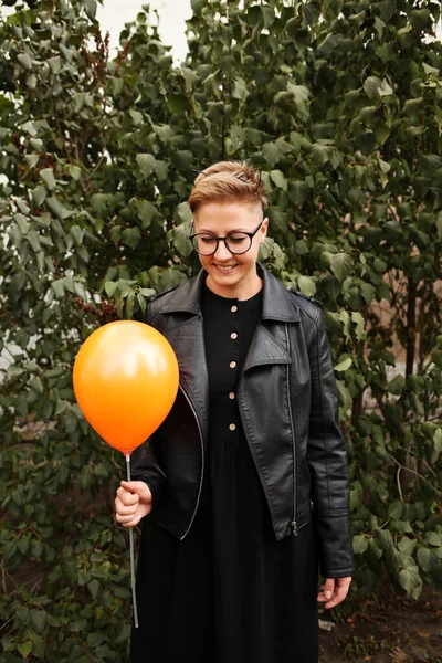 young man in sunglasses holding a balloon