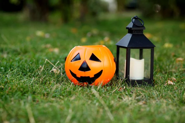 Halloween pumpkin on grass and lamp