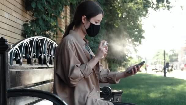 Dziewczyna Ulicy Dezynfekuje Sprayem Telefonu Komórkowego — Wideo stockowe