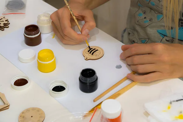 Artist\'s hands, brushes, different colors. The woman is painting. Artist\'s tools for true art and inspiration. A woman makes toys for children by hand at home during quarantine