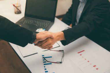 İş adamları iş yerinde el sıkışarak selamlaşırlar..