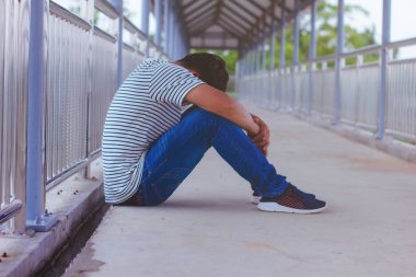 Üstgeçitte oturan adamlar.