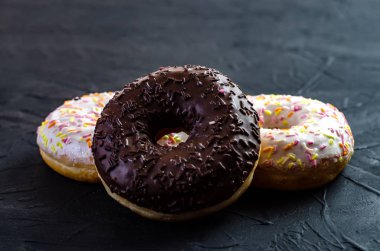 kopya alanı ile karanlık bir arka plan üzerinde çok renkli donut