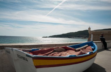 boat and man in village of Sesimbra, Portugal clipart