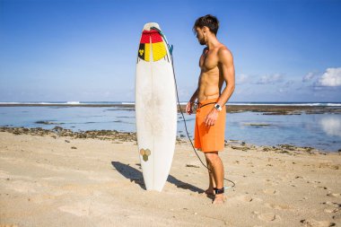 genç sörfçü sörf tahtası Okyanusu yakınlarındaki kum plajındaki bakarak