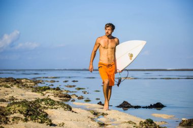 kumsalda yürüyen sörf tahtası ile genç sporcu 