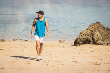 sportif adam deniz, Bali, Endonezya yakınındaki plajda yürüyor