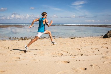 çalışan ve deniz, Bali, Endonezya yakınındaki Kum Plajı üzerinde atlama atletik erkek