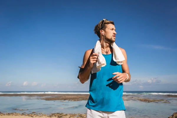 Lekkoatletycznego Mężczyzna Sportowej Ręcznikiem Stojąc Morzu — Darmowe zdjęcie stockowe