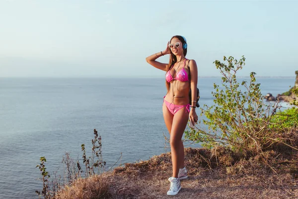 Hymyilevä Houkutteleva Tyttö Kuulokkeet Vaaleanpunainen Bikinit Seisoo Meren Rannalla — kuvapankkivalokuva