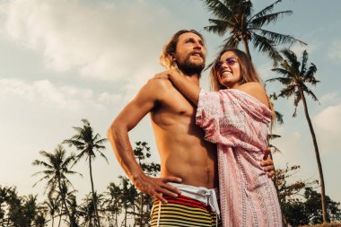 Erkek ve kız arkadaşı Bali, Endonezya kumsalda sarılma düşük açılı görünümü