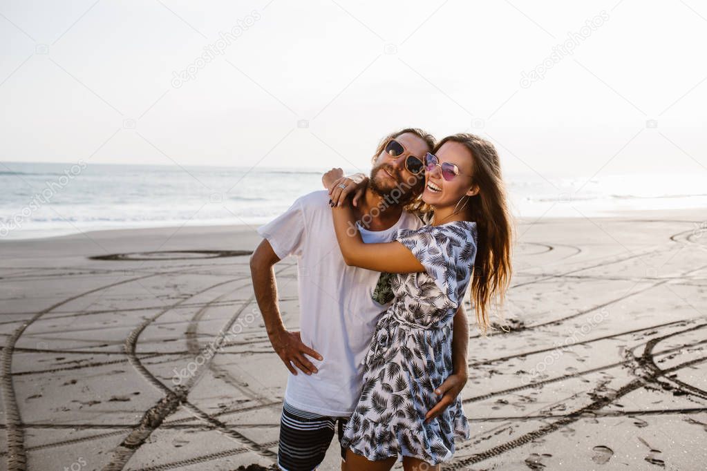 happy couple hugging on beach in bali, indonesia