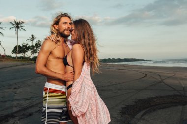 Erkek ve kız arkadaşı Bali, Endonezya kumsalda sarılma