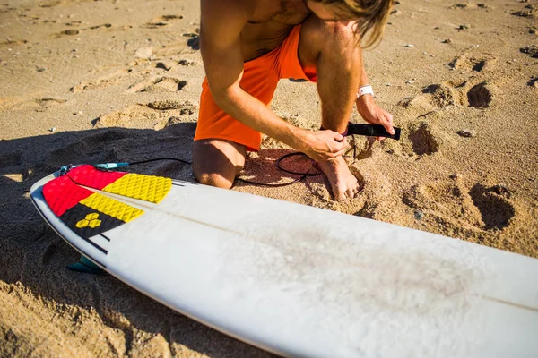 Visão parcial do desportista se preparando para o surf na praia de areia — Fotografia de Stock