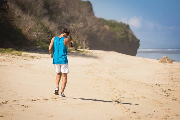 Back view of sportsman walking on beach, Bali, Indonesia — Stock Photo