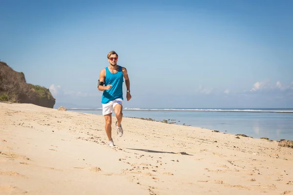 Sportsman running on sand beach near sea, Bali, Indonesia — Stock Photo