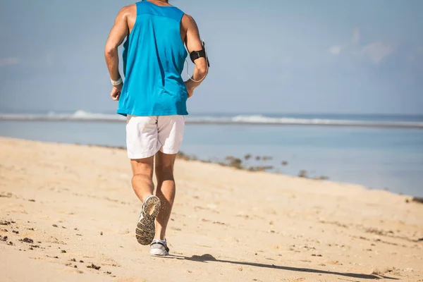 Back view of runner training on sand beach near sea, Bali, Indonesia — Stock Photo