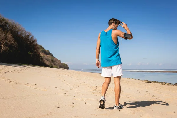 Vue arrière du sportif marchant sur le bord de mer, Bali, Indonésie — Photo de stock