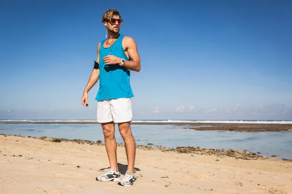 Desportista em óculos de sol em pé na praia, Bali, Indonésia — Fotografia de Stock
